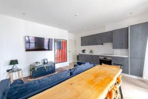 a living room with a blue couch and a table at Charming & Stylish 1BD Flat - Bethnal Green in London