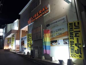 un bâtiment avec un panneau coloré sur son côté dans l'établissement ホテル リベラル 男塾ホテルグループ, à Kobe