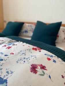 a bed with a blanket with flowers on it at Übernachtung beim Bio-Metzger Zimmer "Karl" in Mössingen