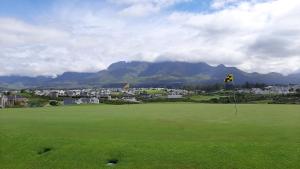a view of a golf course with mountains in the background at Albatross @ Kingswood in George