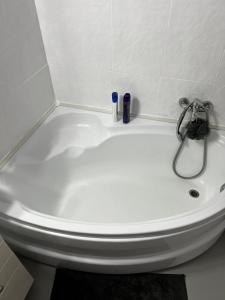 a white bath tub with a faucet in a bathroom at Mona Apartment Taxi#Airport #PARKING#BUCHAREST#THERME in Otopeni