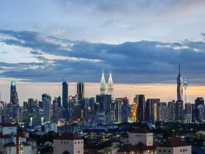 a view of a city skyline at dusk at Space Themed KLCC View Condominium @ 6-8 PAX in Kuala Lumpur