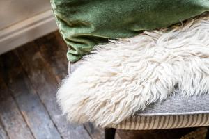 a couch with a green pillow and a white rug at Haven 1 in Sint Anna ter Muiden