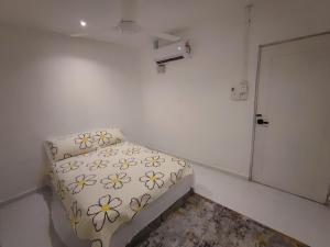 Kleines weißes Zimmer mit einem Bett und einem Kissen in der Unterkunft Hermoso Homestay Kota Bharu in Kota Bharu