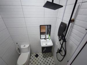 a bathroom with a toilet and a sink at Hermoso Homestay Kota Bharu in Kota Bharu +5 photos