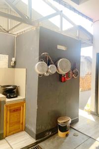 uma cozinha com panelas e frigideiras penduradas numa parede em Pondokan Guest House Rinjani Syariah em Bengkulu