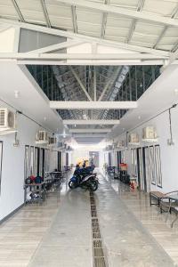 a motorcycle parked in a large room with tables and chairs at Pondokan Guest House Rinjani Syariah in Bengkulu