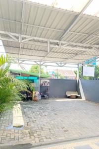 un padiglione con una panchina sotto un tetto bianco di Pondokan Guest House Rinjani Syariah a Bengkulu