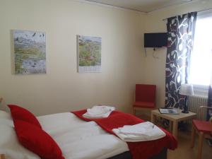 a room with a bed with a red blanket on it at STF Malmfältens Folkhögskola in Kiruna