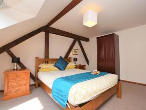 um quarto com uma cama de madeira e uma cómoda de madeira em 2 Bed in Godshill IC106 em Godshill