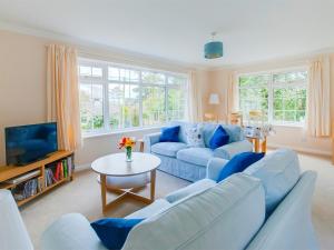 a living room with blue couches and a tv at 2 Bed in Brighstone IC132 in Brighstone