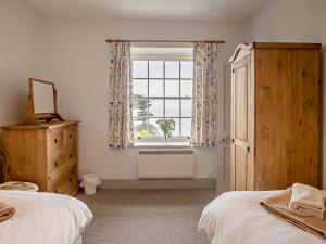 1 dormitorio con 2 camas y ventana en 3 Bed in Niton Undercliff IC125, en Niton