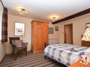 a bedroom with a bed and a chair at 1 Bed in Godshill IC146 in Godshill