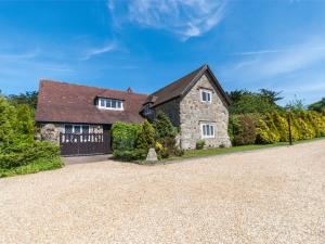a large stone house with a gravel driveway at 1 Bed in Godshill IC146 in Godshill