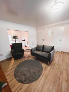 uma sala de estar com duas cadeiras pretas e um tapete em Frisch renovierte Ferienwohnung in ruhiger Lage em Braunfels