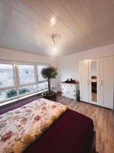 um quarto com uma cama num quarto com janelas em Frisch renovierte Ferienwohnung in ruhiger Lage em Braunfels