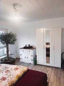 a bedroom with a bed and a cabinet and a tree at Frisch renovierte Ferienwohnung in ruhiger Lage in Braunfels