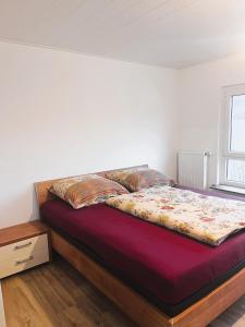 uma cama num quarto branco com um colchão vermelho em Frisch renovierte Ferienwohnung in ruhiger Lage em Braunfels