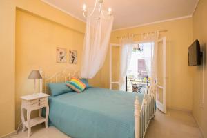um quarto com uma cama azul e um lustre em Orfeas House Corfu em Corfu Town