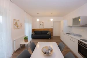 eine Küche und ein Wohnzimmer mit einem Tisch und einem Sofa in der Unterkunft Apartments Agenija Bled in Bled