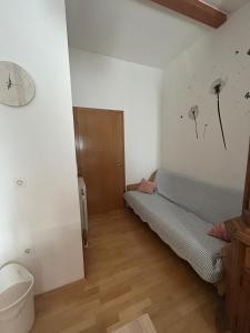 a room with a couch and a clock on the wall at Apartman Anita in Varaždin