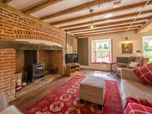 a living room with a brick wall and a fireplace at 3 Bed in North Creake KT033 in North Creake