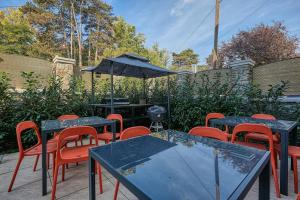 a group of tables and chairs with an umbrella at Villa Botaniq in Sopron