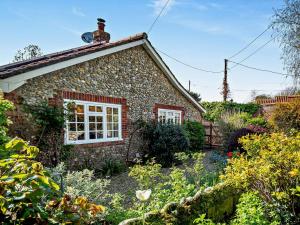 una casa de piedra con un jardín delante de ella en 3 Bed in Cley-next-the-Sea KT036 en Cley next the Sea