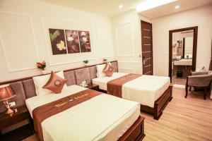 een hotelkamer met 2 bedden en een bureau bij Sen Hotel - Số 23, ngõ 1, Lê Văn Thiêm - by Bay Luxury in Hanoi