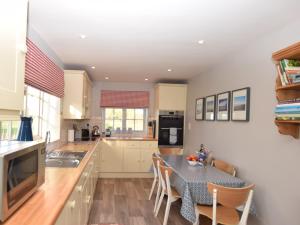 a kitchen with a table and a dining room at 3 Bed in Kettlestone KT037 in Little Snoring