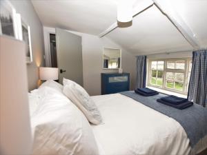 um quarto com uma grande cama branca e uma janela em 3 Bed in Kettlestone KT037 em Little Snoring