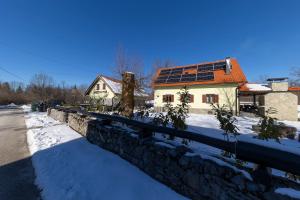 uma casa com painéis solares no telhado na neve em SPA HOLIDAY HOUSE REŽEK - Lovinac em Lovinac