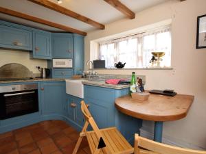 a kitchen with blue cabinets and a wooden table at 2 Bed in South Creake KT117 in North Creake