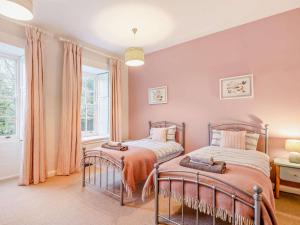 two beds in a bedroom with pink walls at 4 Bed in Snettisham KT124 in Snettisham