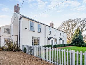 a white house with a white picket fence at 4 Bed in Snettisham KT124 in Snettisham