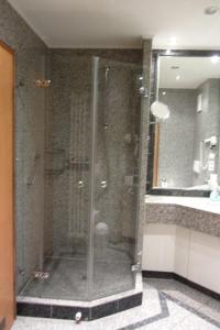 una doccia in vetro in un bagno con lavandino di Dünenpark Binz - Düne 11 Apartment 89 a Binz Altre 17 foto