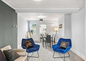 ein Wohnzimmer mit blauen Stühlen und einem Tisch in der Unterkunft 3 Bedroom House, great location - Big special offer for long-term stays in North Hykeham