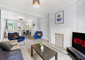 sala de estar con sillas azules y chimenea en 3 Bedroom House, great location, family & business trip en North Hykeham