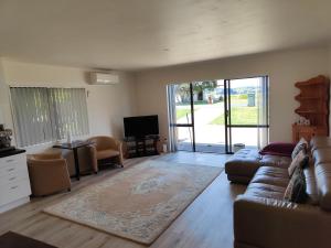 a living room with a couch and a tv at Harbourside Haven in Ohope Beach