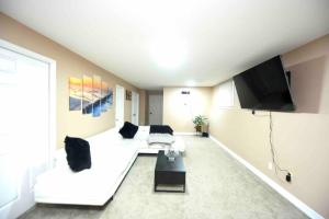 a living room with a white couch and a flat screen tv at Adorable Spacious Inn with Indoor fireplace in Kingston