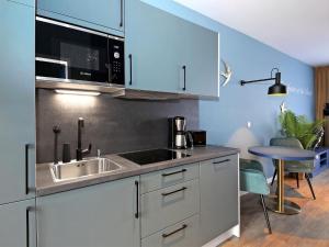 eine Küche mit einer Spüle und einer Mikrowelle in der Unterkunft Seebrücke Heringsdorf - 1-Raum-Appartement mit Balkon S7a in Heringsdorf