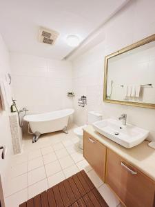a white bathroom with a tub and a sink at Country Style Anping Homestay in Tainan