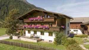 una casa con un balcón con flores. en Ausserwieserhof, en Neustift im Stubaital