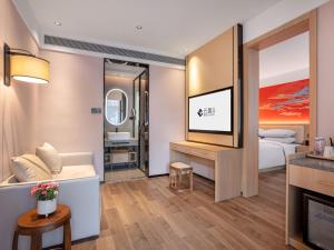 北京市にあるYunju Hotel Beijing Yonghe Palace Guijie Siheyuanのベッドとテレビが備わるホテルルームです。
