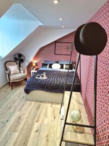 a bedroom with a bed and a red wall at L'élémentaire, appartement chic et central in Mulhouse