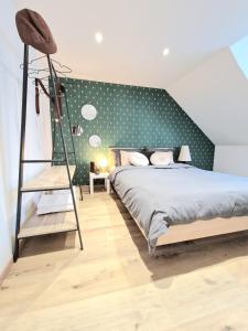 a bedroom with a bed and a green wall with polka dots at L'élémentaire, appartement chic et central in Mulhouse