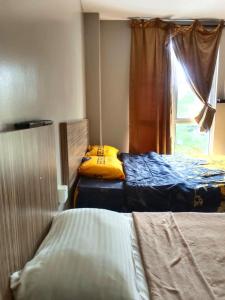 a bedroom with two beds and a window at Brilliant Empire Hotel in Melaka