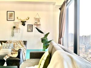 un soggiorno con divano e finestra di Tropicana 218 Macalister - Top Floor Boho 3 BR Spacious Suite a George Town