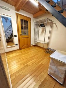 特伦托Casa Mazzini的一间铺有木地板的客房,设有木门