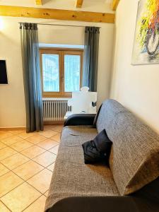 een woonkamer met een bank en een raam bij Casa Mazzini in Trento